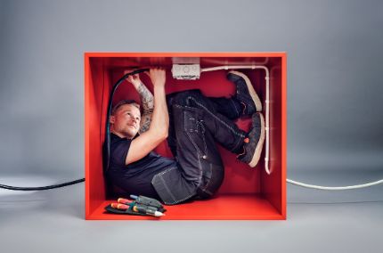Elektriker i liten boks som demonstrerer TXXP FLEX90s smidighet